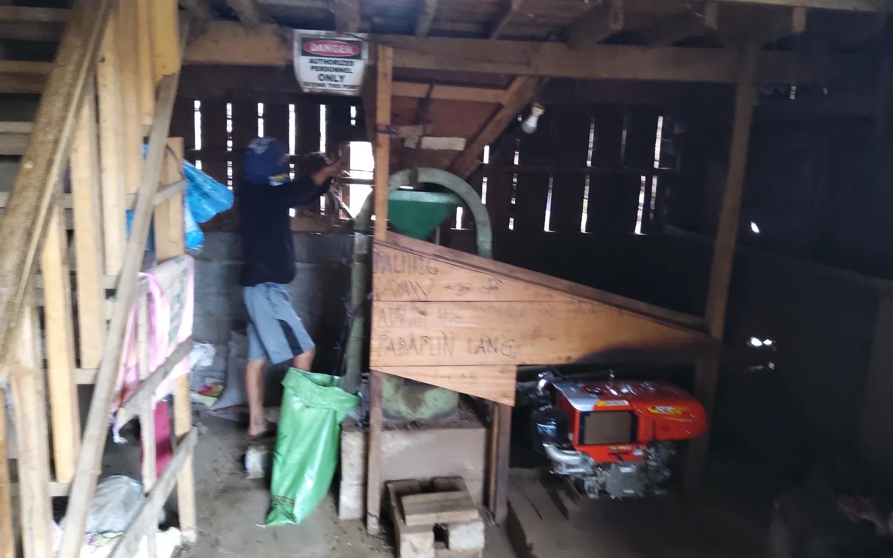 A worker operating coffee processing equipment inside a BMMPC facility